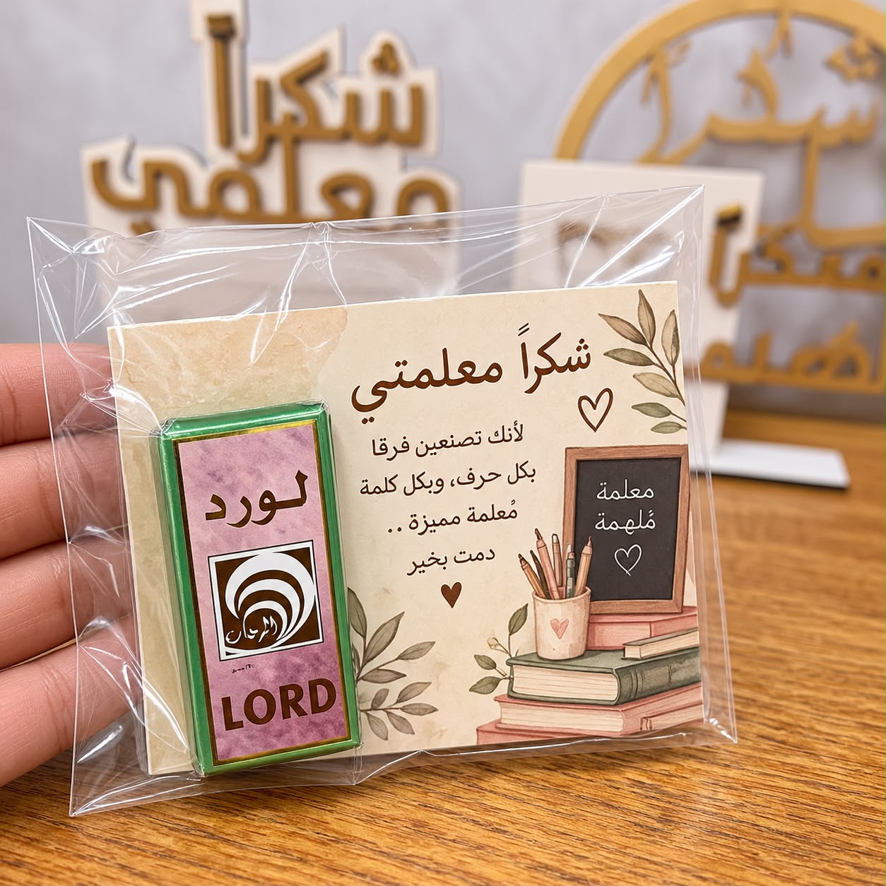 عطر صغير مغلف مع بطاقة للمعلم